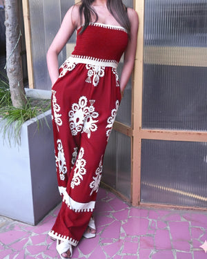 Person wearing a red and white patterned outfit standing outdoors.