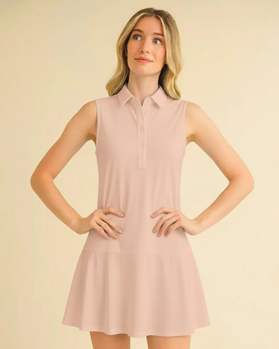 Woman wearing a light pink sleeveless dress against a beige background
