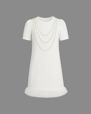 White dress with pearl chain detail on a gray background